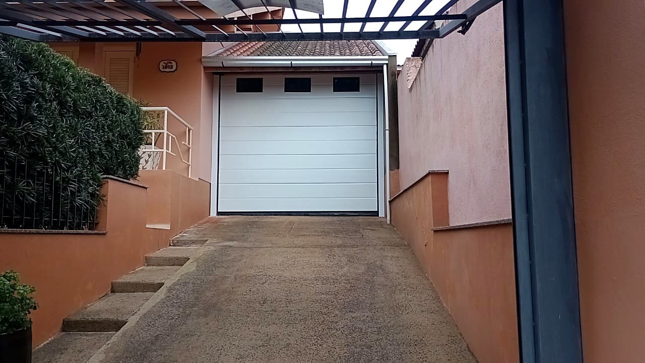 Portão seccional branco Cattani em acesso estreito