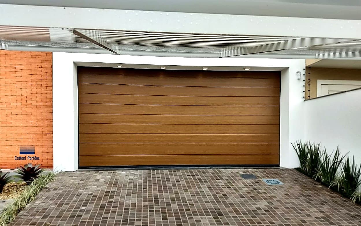 Portão seccional amadeirado Cattani em fachada com tijolo aparente